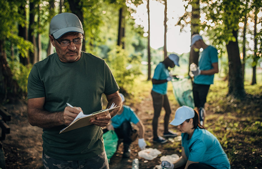 man in woods with volunteers