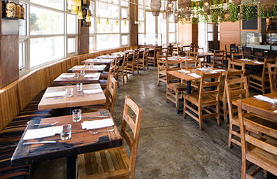 an empty restaurant with set tables near a window