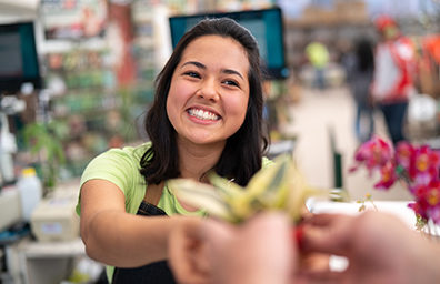 smiling woman giving a customer a product