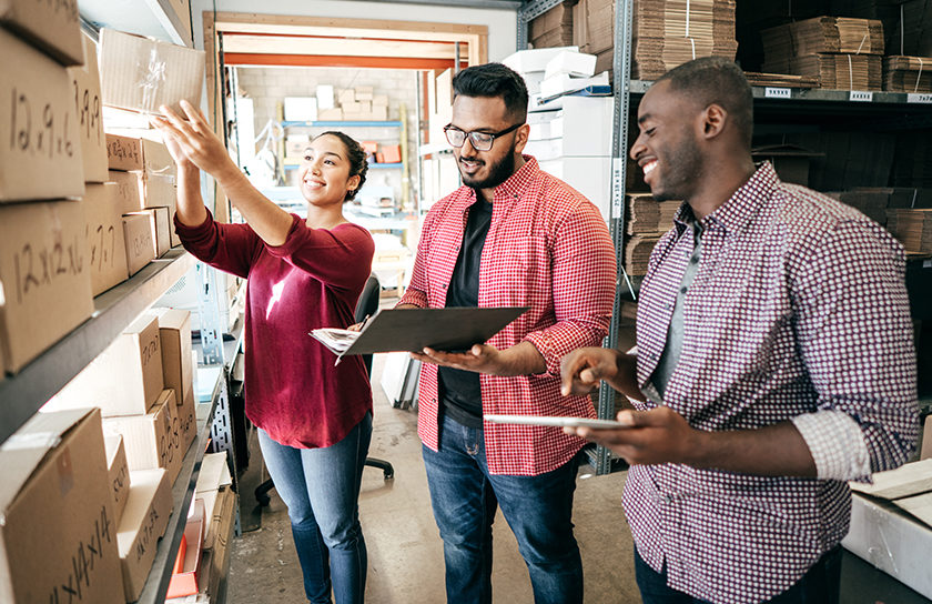 woman and two men looking at packages on a shelf