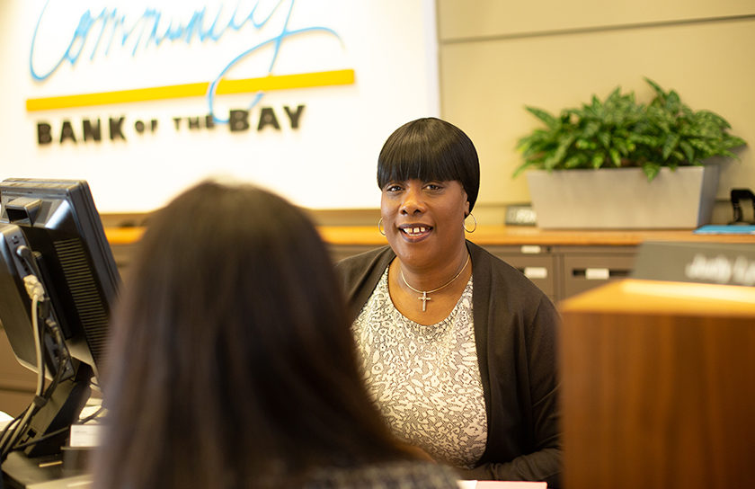 woman teller behind counter helping a woman