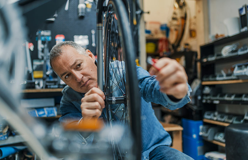 man repairing tire on bicycle in shop