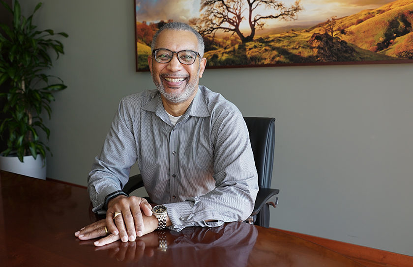 man sitting at desk smiling