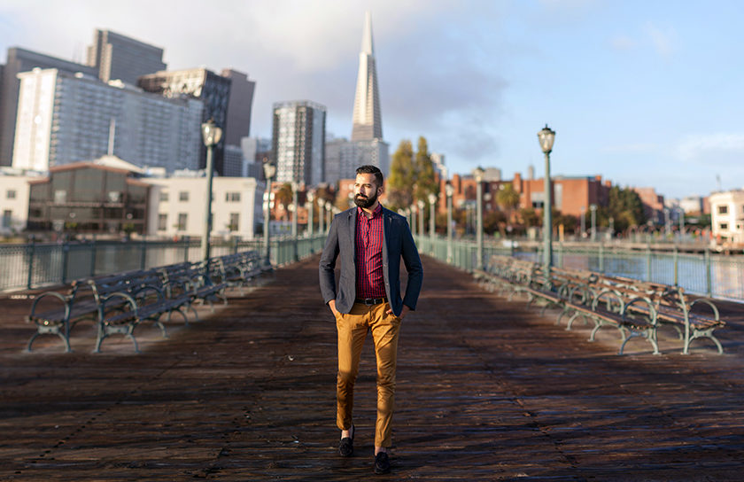 well dressed young man walking on pier