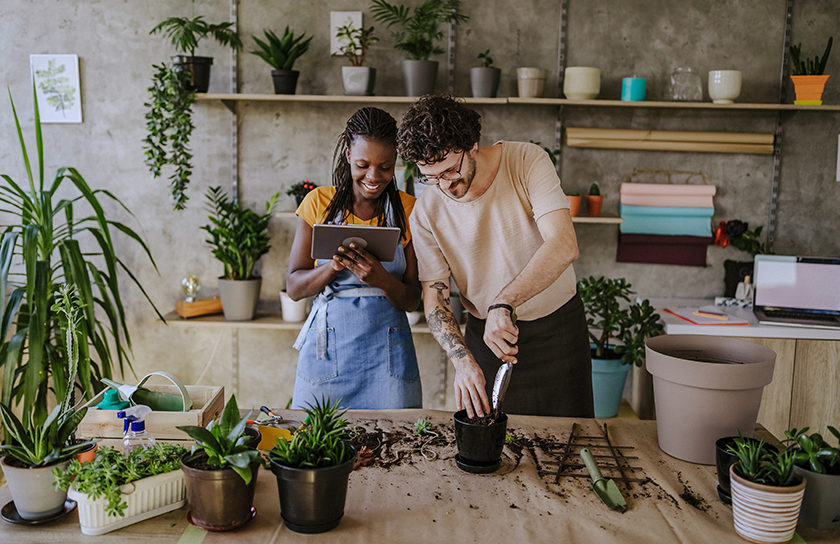 two happy people working on plantings in florist shop