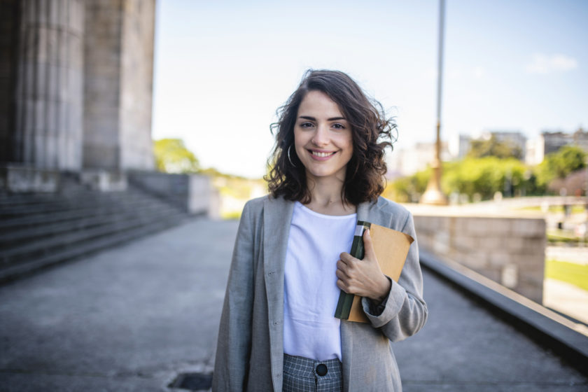 woman standing smiling with books