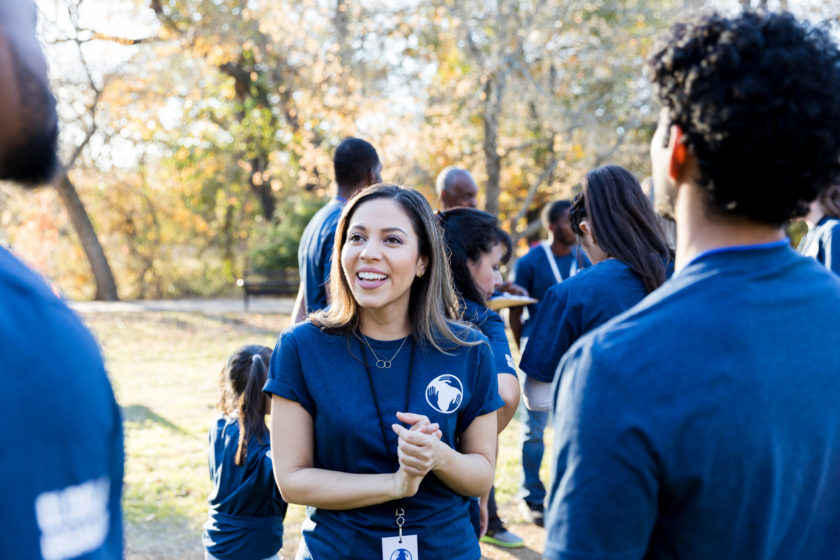 Woman talking to members of an organization outdoors