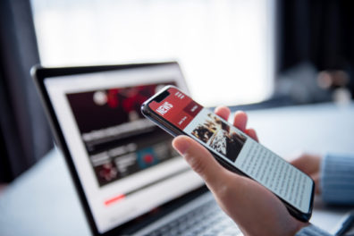 Online news on a smartphone and laptop, Woman reading news or articles in a mobile phone