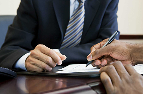 close up of two people signing a form