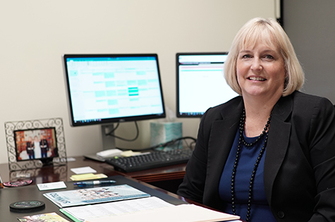 smiling woman in front of computers
